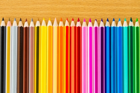 line of colored pencils on wooden backgroundの写真素材