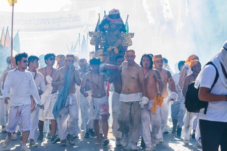 PHUKET - OCT 10: Devotees of a Chinese Taoist shrine carry a palanquin housing a Chinese God idol in...