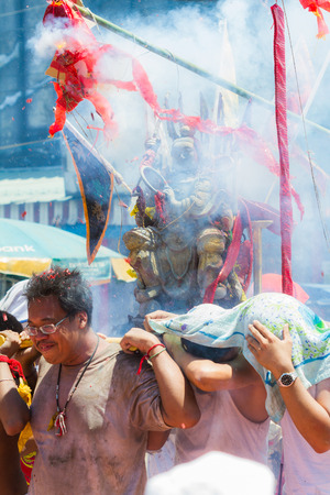 PHUKET - OCT 11  Devotees of a Chinese Taoist shrine carry a palanquin housing a Chinese God idol in a street procession to mark the Phuket Vegetarian Festival on Oct 11, 2013 in Phuket, Thailand のeditorial素材