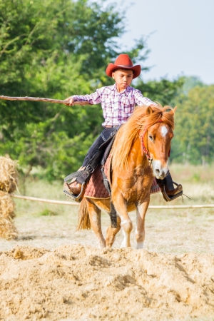 PRACHUAPKHIRIKHAN, THAILAND - DECEMBER 14 : A cowboy in action during on fair of competition the animals "Livestock Show 2013" on December 14, 2013 in Pranburi, Prachuapkhirikhan, Thailandのeditorial素材