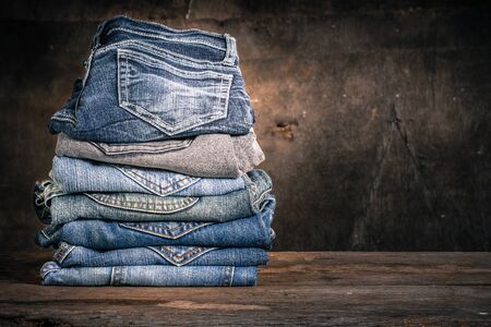 Close up of many jeans trouser stack on wooden vintage backgroundの写真素材