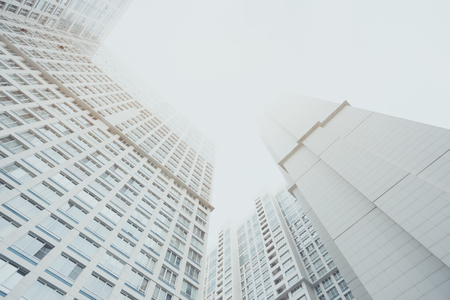 White contemporary residential skyscraper apartment building in Moscow on a cloudy day, two housing...