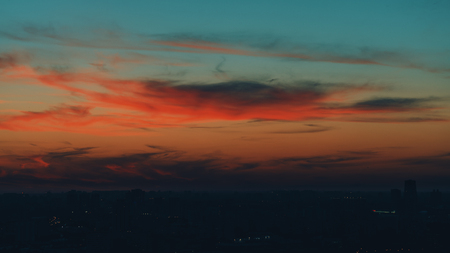 Dramatic red and teal scenery of the city silhouette at sunsetの写真素材