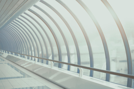 Teal and blue futuristic abstract glass and steal tunnel receding into the distance with regular...