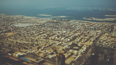 True tilt shift shooting from top of Dubai: residential buildings, highways and coastline with sea and islands, sunny summer dayの写真素材