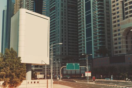 Mock up of blank vertical white advertising billboard in Dubai with residential and office modern contemporary skyscrapers and empty highway behindの写真素材