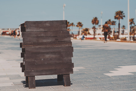 Mock up of wooden black planking banner staying on paving stone in Barcelona beach Barceloneta on summer sunny day with palms, people and teal sky in blurred backgroundの写真素材