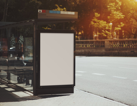 City bus stop with empty mock up banner for your advertising, blank billboard with copy space area for your text message or promotional content, public information board in urban settingの写真素材