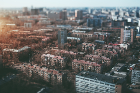True tilt shift view from high point of residential district in metropolitan city in the morning, with multiple houses, road junction in foreground and blurred background with strong bokehの写真素材