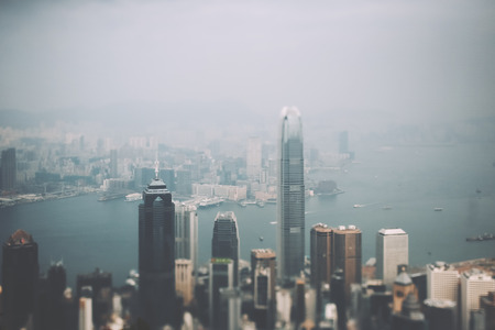 True tilt shift shooting from top of metropolitan city: modern business and office skyscrapers, residential houses and districts, bay with multiple boats and ships, hazy horizon, Bangkok, Thailandの写真素材