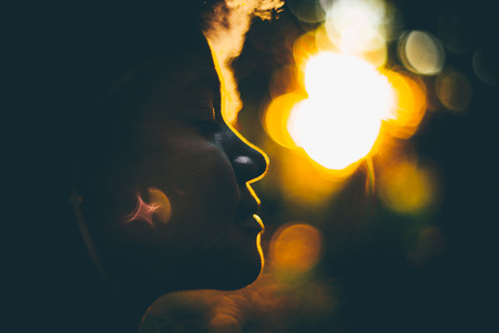 True tilt-shift side view silhouette of beautiful curly Brazilian lady backlighted by stunning...