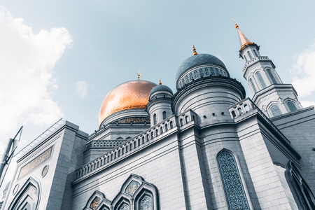 View from bottom side of beautiful Grand Cathedral Mosque made of stone: golden dome and spires with quotation from Quran, sunny autumn day, Moscow, Russiaの写真素材