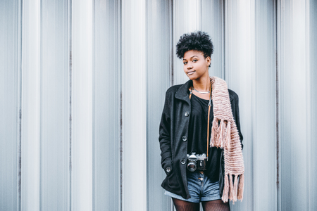 Glamorous young African American tourist girl in coat and comforter,の写真素材