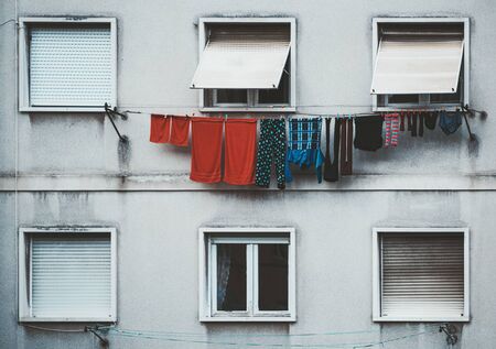 Close up view of a facade of an ordinary residential building in Lisbon with two rows of windows and the row of drying colorful clothes on a summer day, Portugalの写真素材