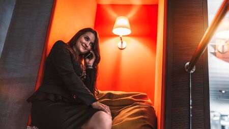 A mature caucasian woman entrepreneur is sitting on a cushion in the recess, indoors of an office...