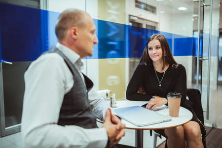Business conversation of two colleagues inside of a coffee point and kitchen of a modern office: a...