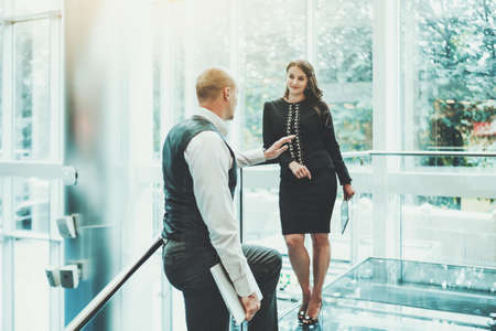 A business talk of two partners on the top floor of a luxurious office skyscraper in the meeting...