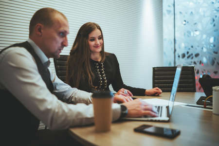 A business meeting in a boardroom of two colleagues with a selective focus on the caucasian...