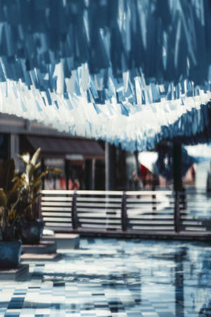 A vertical view of an urban public area with bluish and white tapes hanging on the top a blue-tiled...