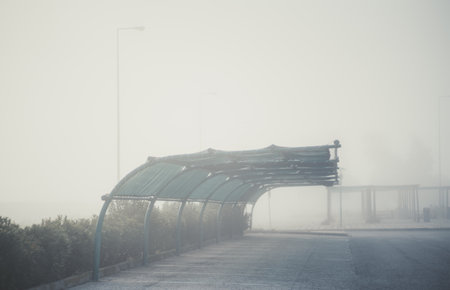 View of an empty foggy covered car parking on a territory of a typical gas station zone of Portugal;...