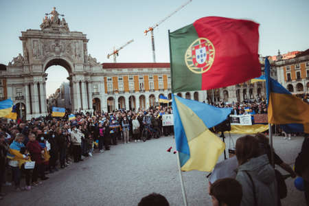 Lisbon, Portugal - March 6, 2022: a protest action in support of Ukraine, against Russian military invasion and war: a crowd of Ukrainian protesters with posters, flags, and placards; center of Lisbonのeditorial素材