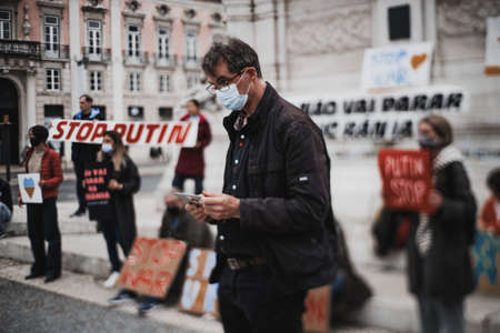 Lisbon, Portugal - February 24, 2022: true tilt-shift shot of a protestor standing in front of a row...