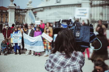 Lisbon, Portugal - March 13, 2022: protest rally against Russian incursion into Ukraine and war: true tilt-shift view of the TV operator with camera in front of group of protesters; selective focusのeditorial素材