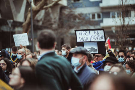 Lisbon, Portugal - February 27, 2022: a crowd of people in front of the Russian embassy in Lisbon protesting in support of Ukraine, against the invasion; selective focus on an antiwar posterのeditorial素材