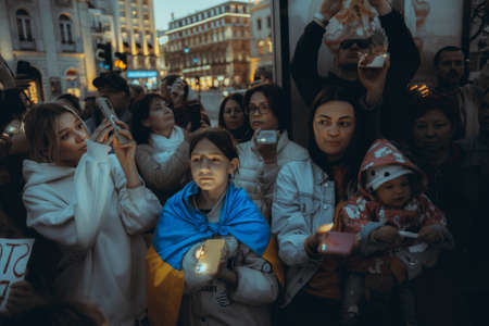 Lisbon, Portugal - April 20, 2022: a night protest action dedicated to saving the Ukrainian city of Mariupol which was almost totally destroyed by Russia; people shine their cell phone flashlights upのeditorial素材