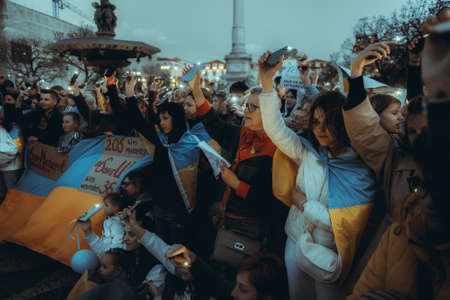 Lisbon, Portugal - April 20, 2022: a night protest action dedicated to saving the Ukrainian city of Mariupol which was almost totally destroyed by Russia; people shine their cell phone flashlights upのeditorial素材