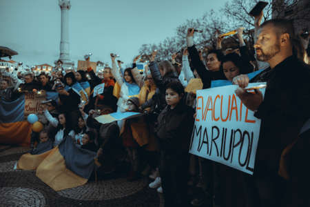 Lisbon, Portugal - April 20, 2022: a night protest action dedicated to saving the Ukrainian city of Mariupol which was almost totally destroyed by Russia; people shine their cell phone flashlights upのeditorial素材