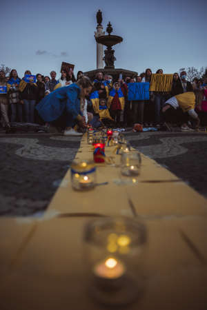 Lisbon, Portugal - April 20, 2022: a night protest rally dedicated to saving the Ukrainian city of Mariupol which was almost totally destroyed by Russia; burning candles in memory of the deadのeditorial素材