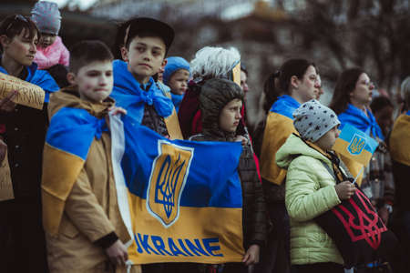 Lisbon, Portugal - April 20, 2022: protest action dedicated to saving the Ukrainian city of Mariupol from the Russian troops; protesters with posters, a group of children holding the Ukrainian flagのeditorial素材