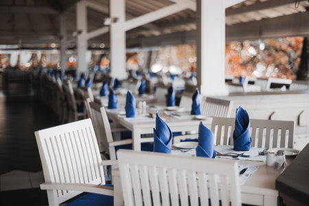 A selective focus view on a dinner table setting and silverware in a tropical restaurant in the...