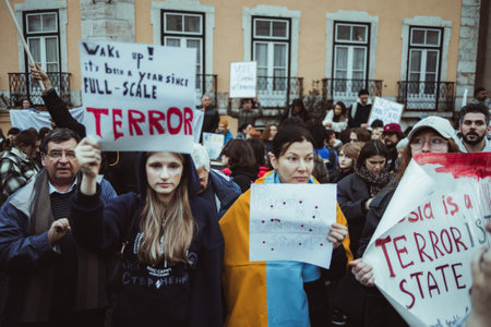 Lisbon, Portugal - February 24, 2023: In the front row of a protest marking the one-year anniversary of the conflict in Ukraine, some women in focus hold cardboards with powerful anti-war messagesのeditorial素材