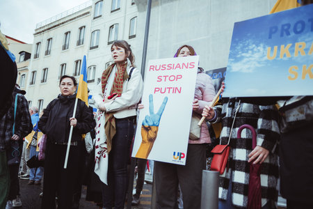 Lisbon, Portugal - February 24, 2023: Women together to protest against war, holding the Ukrainian flag and powerful anti-war messages on banners marking the one-year anniversary of the war in Ukraineのeditorial素材