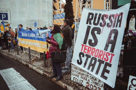 Lisbon, Portugal - February 24, 2023: Amidst a group of protesters holding flags and boards, a woman shouts through a megaphone at a protest marking the one-year anniversary of the conflict in Ukraineのeditorial素材