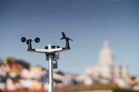 A sleek black and white wireless weather station is in sharp focus against a dreamy defocused backdrop of Lisbon; The device is designed to provide accurate weather information, an indispensable toolの写真素材