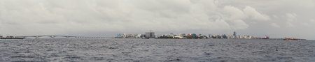 Panoramic shot of the cityscape of Male, the long bridge dominates the right side of the image, surrounded by the sea. The unique blend of urban life and stunning natural surroundings in the Maldives.の写真素材