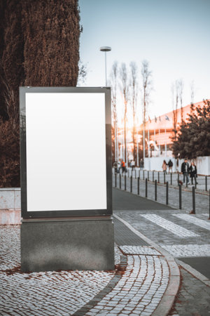 Lisbon; A vertical mock-up for an advertisement, featuring a white empty billboard in the middle of the sidewalk next to a zebra crossing, offers ample space for customized ads.の写真素材