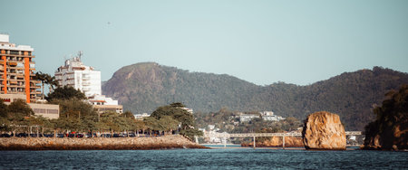Panoramic telephoto coastal view of Niteroi, Brazil with Ponte da Boa Viagem bridge across Guanabara Bay, urban waterfront, mountains and huge granite rock by the seaの写真素材