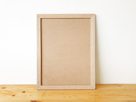 Vertical wooden frame mock up. Blank wooden frame cork board on wooden floor with white wall. Mockup template for your design. Simple Blank picture frame on wooden table.の写真素材