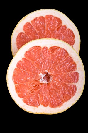 Red halved grapefruit with black backgroundの写真素材