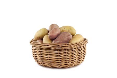 Yellow and red potatoes in the basket in front of white backgroundの写真素材