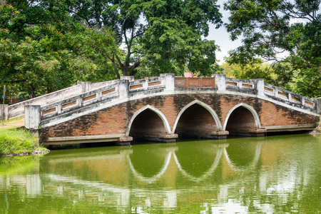 Old pedestrian bridge over a river in the historic city Ayutthaya, Thailandの写真素材
