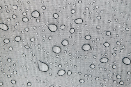 Raindrops on a gray tent canvasの写真素材