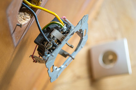 A socket hanging out of the wall during the renovation of a roomの写真素材