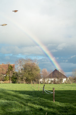 A village idyll is further embellished by a fantastic rainbowの写真素材