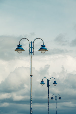 Three blue street lamps of the same design stand in a row like the Orgenpfeiffen in front of a...