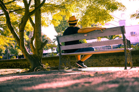 The lonely man sit on the chair in the parkの写真素材
